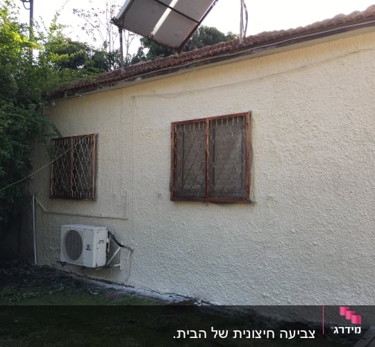קיר חיצוני צבוע בצבע בהיר עם מזגן חיצוני